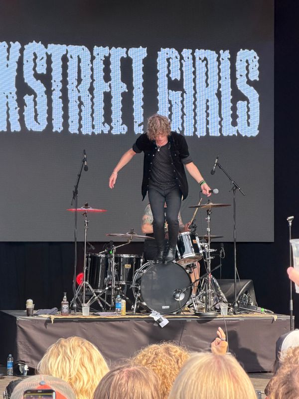 Vokalisten i Backstreet Girls står på basstromma foran publikum