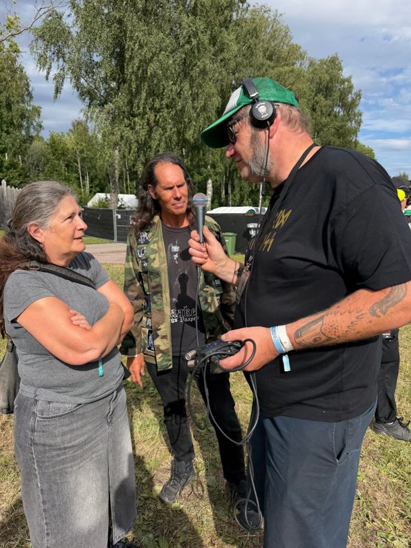 Max intervjuer to festivalgjester med mikrofon og opptaker