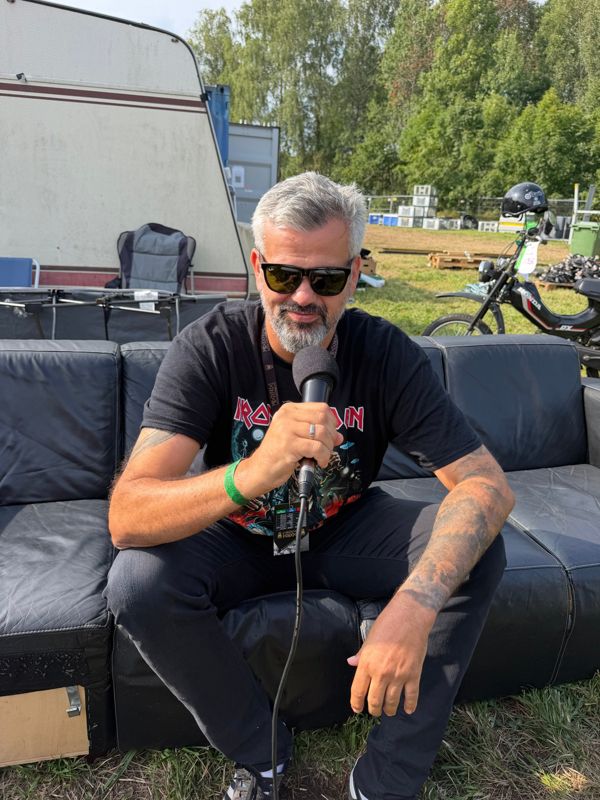 En gjest i Iron Maiden-t-skjorte intervjues i sofaen