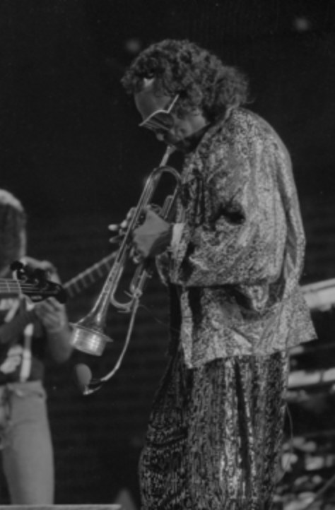 Miles Davis på scenen, med trompeten pekende ned mot gulvet.